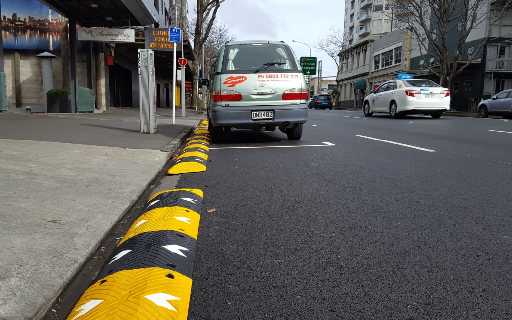 Speed bumps being used as barriers to prevent buses from hitting roadside obstacles.