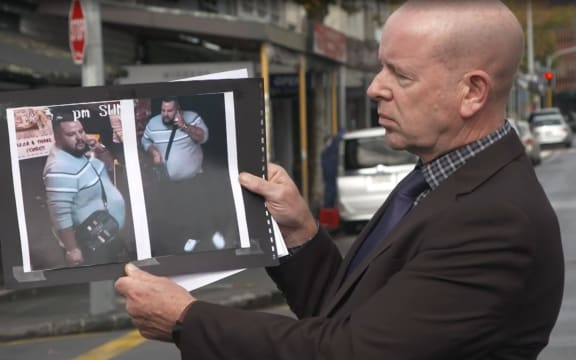 D.I Chris Barry holds up a photograph of an alleged offender involved in a homicide on Ponsonby Road.
