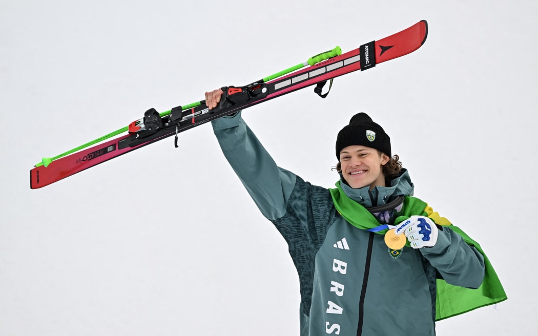 Brazil's gold medalist Lucas Pinheiro Braathen celebrates on the podium of the men's giant slalom alpine skiing event during the Milano Cortina 2026 Winter Olympic Games at the Stelvio Ski Centre in Bormio (Valtellina) on February 14, 2026. (Photo by Fabrice COFFRINI / AFP)