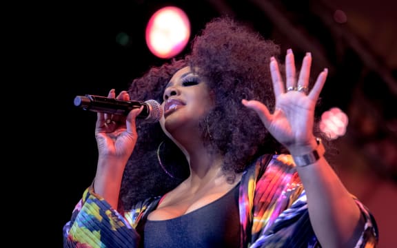 US singer Lalah Hathaway holds a microphone, closes her eyes and sings into it
