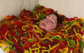 Kylie Lowe sumberged in jelly snake sweets for A Current Affair