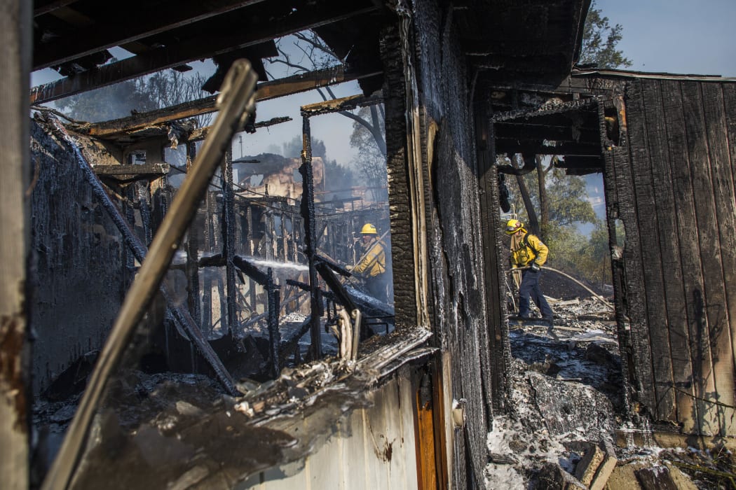 Firefighters battle the Tick Fire in houses on fire in Brentwood, California.