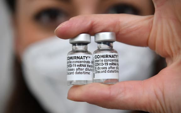 Topic picture - vaccination with the Comirnaty mRNA vaccine from BionTech Pfizer. Vaccine doses with vaccine for injection with a cannula. Close up.