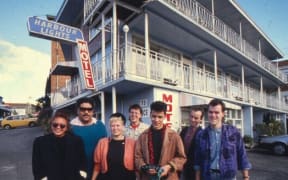The Holidaymakers check out the Harbour Lights Motel, Parnell, 1988. From left: Mara Finau, Pati Umaga, Barbara Griffin, Richard Caigou, Peter Marshall, Stephen Jessup, and Andrew Clouston.