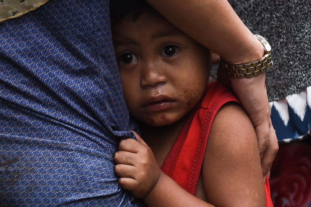 A boy clutches to his mother after residents where evacuated from their homes on the outskirts of Marawi on the southern island of Mindanao this week.