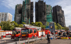 A man looks at the aftermath of a major fire that swept through several apartment blocks at the Wang Fuk Court residential estate in Hong Kong's Tai Po district on 28 November, 2025.