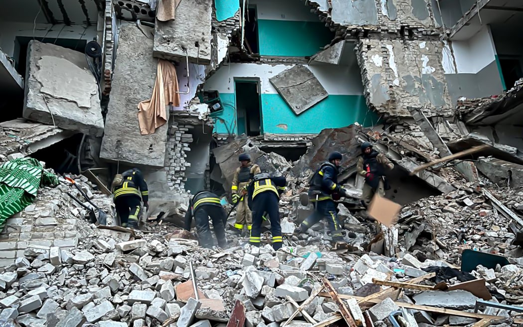 In this handout photograph taken and released by the Ukrainian Emergency Service on November 19, 2024, Ukrainian rescuers clean rubble of a destroyed dormitory building following a  missile attack in Glukhiv, Sumy region, amid the Russian invasion of Ukraine. - A Russian strike overnight killed twelve people including a child in the eastern Ukrainian region of Sumy, which has faced an increase in deadly attacks, President Volodymyr Zelensky said on November 19, 2024. (Photo by Handout / UKRAINIAN EMERGENCY SERVICE / AFP) / RESTRICTED TO EDITORIAL USE - MANDATORY CREDIT "AFP PHOTO / UKRAINIAN EMERGENCY SERVICE" - NO MARKETING NO ADVERTISING CAMPAIGNS - DISTRIBUTED AS A SERVICE TO CLIENTS
