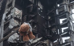 Borodyanka, UKRAINE - APRIL 6: A teddy bear hanging from a tree in front of a building bombed by the Russian army in Borodyanka (Ukraine), 6 April 2022.