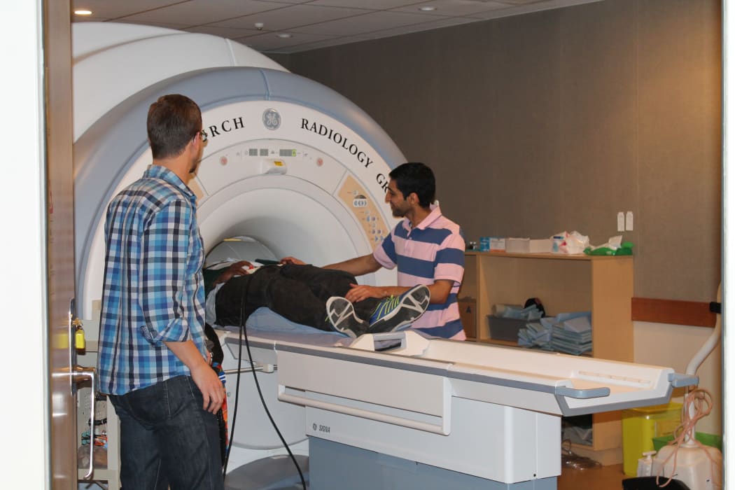 Christchurch collaborators are helping to run the scans. Mustafa Almuqbel prepares a research team member for his MRI. Tracy Melzer of the New Zealand Brain Institute is in the foreground.