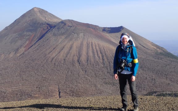 Christ Conway is wearing tramping gear and standing in front of a Japanese volcano.