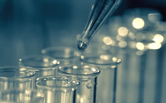 15139167 - pipette adding fluid to one of several test tubes