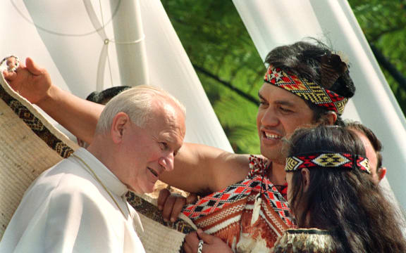 Pope John Paul II tries on a traditional Maori gown which he received in a welcoming ceremony 22 November 1986 in Auckland.