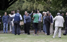 Police talk to witnesses near a mosque in central Christchurch, New Zealand, Friday, March 15, 2019.