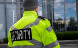A security guard in uniform patrolling a residential area.