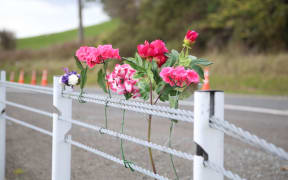 Flower were left at the roadside where an unladen logging truck hit the car the men were travelling in.