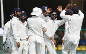 Indian cricketers celebrate a Ravindra Jadeja wicket.
