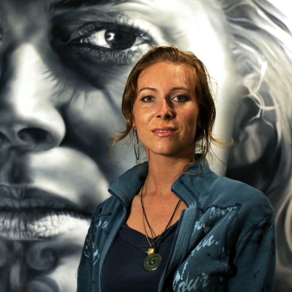 Artist Sofia Minson with one of her pieces in the background.