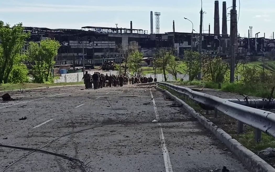 A shot from a Russian Defence Ministry video shows Ukrainian service members walking in line on 17 May as they leave the Azovstal steel plant in Mariupol.