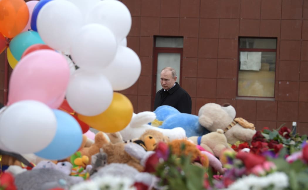 Russian President Vladimir Putin lays a flower at the shopping mall in Kemerovo where over 64 people were killed on March 25, in Kemerovo, Russia on March 27, 2018.