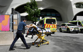 A paramedic pushes a bed towards his ambulance in Melbourne on October 9, 2021, as Victoria state recorded 1965 new Covid cases, its highest daily infection number since the start of the pandemic, putting more pressure on the state's struggling health system. (Photo by William WEST / AFP)