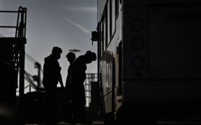 Migrants, picked up at sea while attempting to cross the English Channel, get into a bus to be taken for processing, after disembarking from a UK Border Force boat at the Marina in Dover, on the south-east coast of England, on 18 April, 2022.