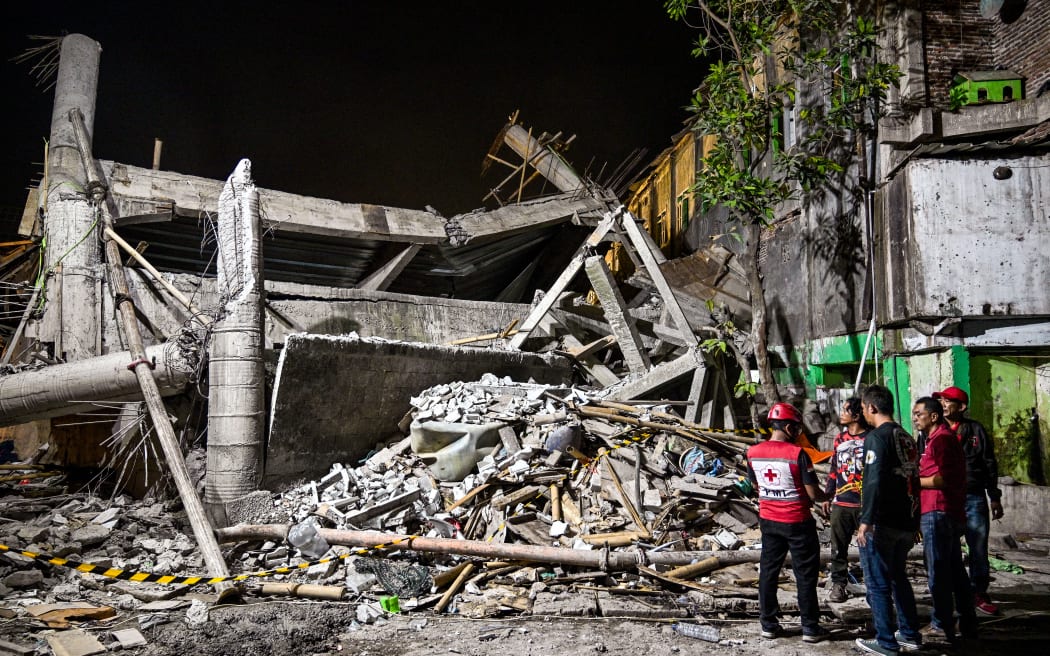 Rescue personnel inspect the site after a building collapsed at an Islamic boarding school in Sidoarjo, East Java province on September 29, 2025, injuring a number of students and trapping several others under the rubble. (Photo by Juni KRISWANTO / AFP)