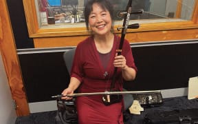 Nancy poses with traditional Chinese instrument called an er hu