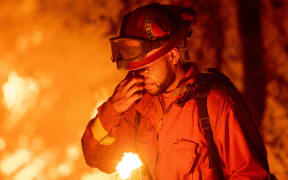 An inmate firefighter pauses during a firing operation as the Carr fire continues to burn.