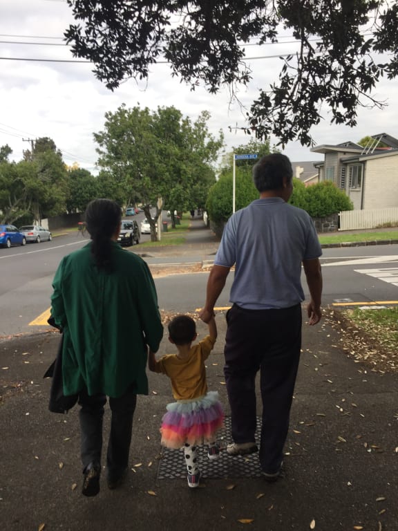 Helen Zhao's parents and their granddaughter taking a walk in Auckland.