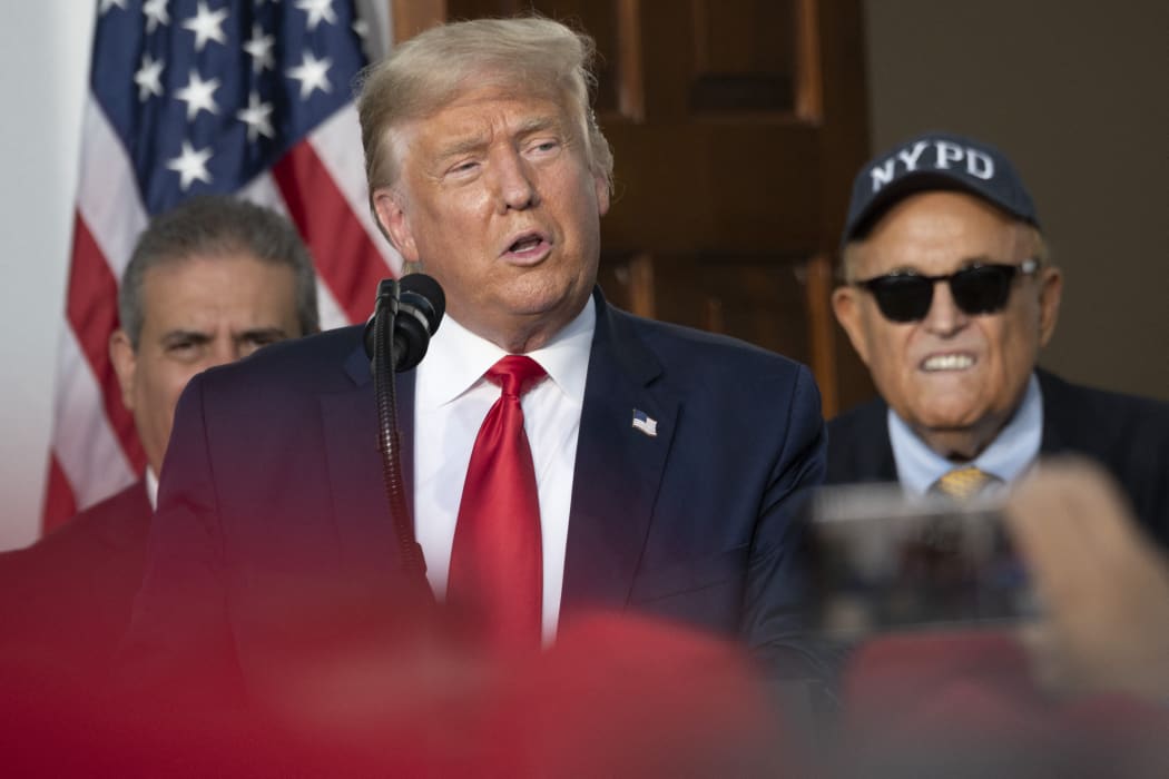 President Donald Trump's personal lawyer Rudy Giuliani listens as US President Donald Trump delivers remarks to the City of New York Police Benevolent Association at the Trump National Golf Club in Bedminster, NJ, on August 14, 2020.