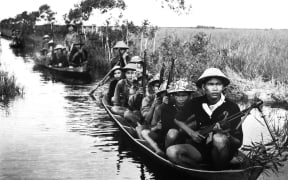 Viet Cong fighters crossing a river during the Vietnam War.