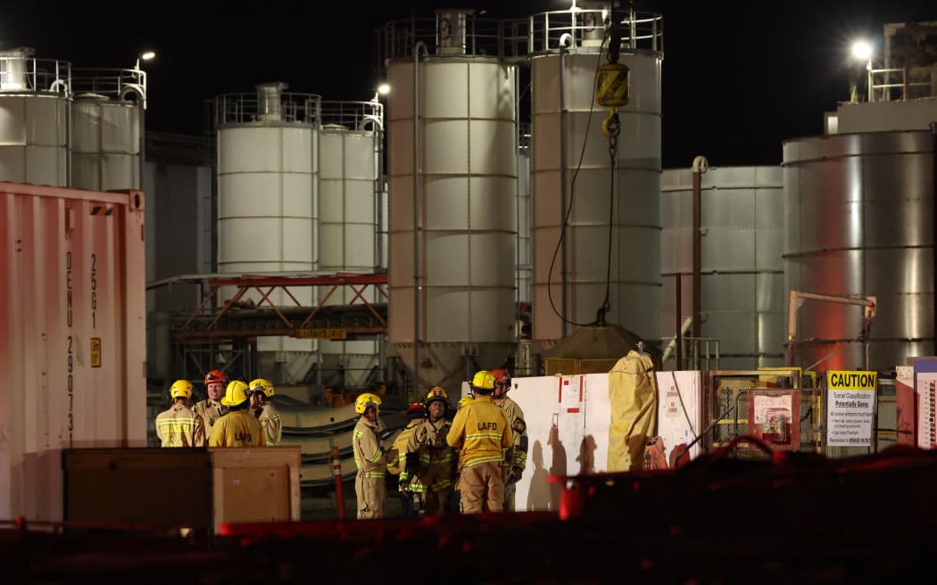 Los Angeles Fire Department (LAFD) firefighters are seen at the site of an industrial tunnel collapse in the Wilmington neighborhood of Los Angeles on July 9, 2025. 31 workers were safely removed from the tunnel without visible injuries, the LAFD said on July 9. (Photo by Patrick T. Fallon / AFP)