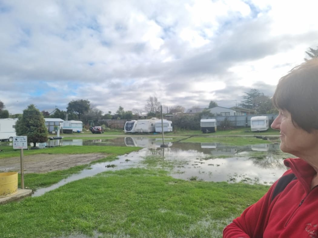 Waikuku Beach Holiday Park owner Debbie Jefcoate and the pooling floodwaters at the park.