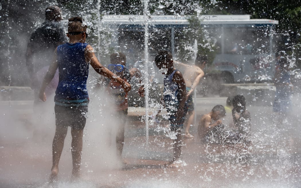 Children enjoy a splash pad on the Greenway during a heatwave in Boston, Massachusetts, on June 19, 2024. Extreme heat and high humidity smothered the central and northeastern US on June 18, 2024, with temperature records expected to melt away in the coming days, authorities warned. Forecasters predicted temperatures could hit 100 degrees Fahrenheit (about 38 Celsius) in parts of New England by June 20. (Photo by Joseph Prezioso / AFP)
