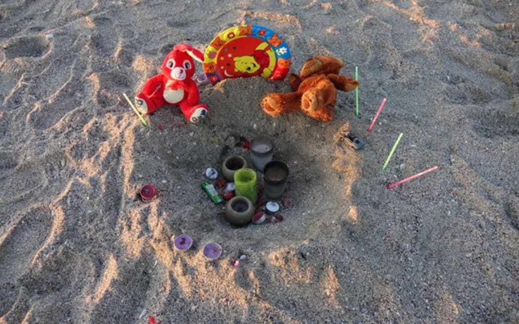 toys and flowers left on the beach