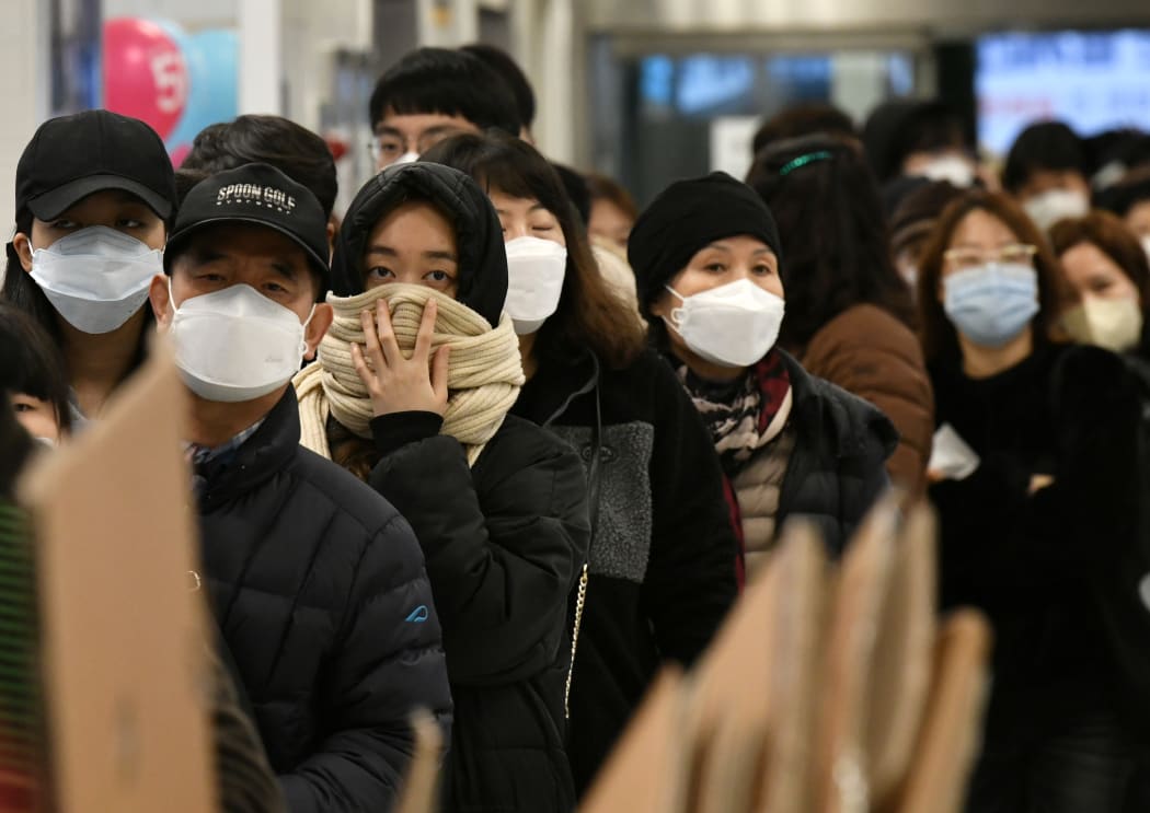 People wait in a line to buy face masks at a shop in the city of Daegu, South Korea, 22 February 2020.