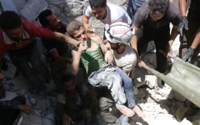 White Helmet volunteers carry a boy they rescued from rubble in Aleppo.