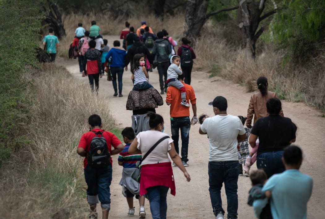 Asylum seekers, most from Honduras, walk towards a US Border Patrol checkpoint after crossing the Rio Grande from Mexico on March 23, 2021 near Mission, Texas.