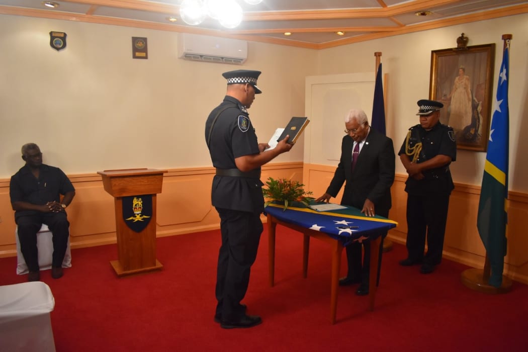 Solomon Islands police commissioner Mostyn Mangau taking his oath of affirmation before governor general Sir David Vunagi.
