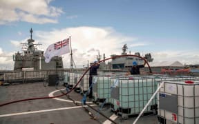 HMNZS Te Mana ship’s company load supplies on board as part of preparations to leave Auckland Harbour bound for Napier as part of Op Awhina.  Supplies include two generators, water, food donated by Foodstuffs as well as items of clothing.