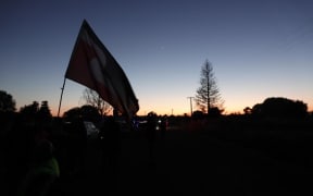 A Tino Rangatiratanga flag flies as the sun rises over Wairoa.