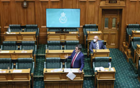 Chris Bishop speaks in the Hybrid House, with a screen at the back of the National benches allowing MPs to watch those who remote into proceedings.
