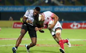 Japan's Yusaku Kuwazuru goes head to head against Fiji's Sevuloni Mocenacagi on day one of the Dubai Sevens