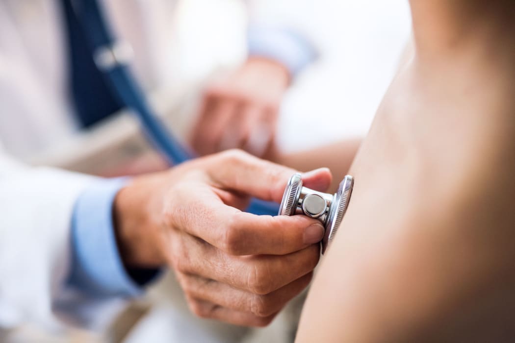 Doctor using stethoscope in examining a small boy