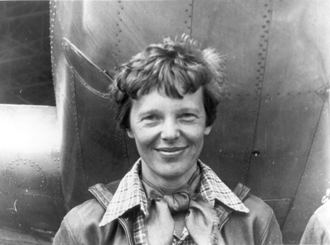 Amelia Earhart standing under the nose of her Lockheed Mode 10-E Electra