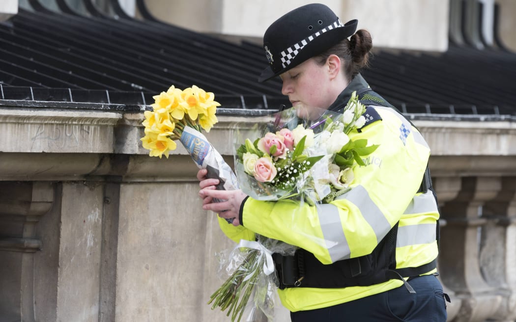 A police officer with flowers the day after Terror attack in the heart of London, Westminster. London.