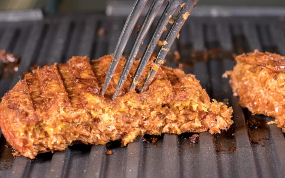 Close shot of the meat like plant-based patties for vegetarian beef burgers being grilled on hot griddle