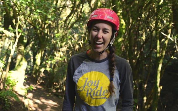 Young woman with cycle helmet standing on trail in the bush