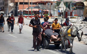 Displaced Palestinians are fleeing from Gaza City and are walking along Salah al-Din Street as they are arriving at the Nuseirat refugee camp in the central Gaza Strip on July 10, 2024, amid the ongoing battles between Israel and the militant group Hamas. (Photo by Majdi Fathi/NurPhoto) (Photo by MAJDI FATHI / NurPhoto / NurPhoto via AFP)