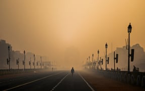A man walks along Rajpath amid smoggy conditions in New Delhi on January 28, 2021.